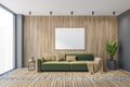 Mockup canvas frame over green sofa in wooden living room with big window