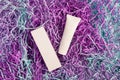 Mockup of a cardboard box and tube of cream, lots of colored purple packing paper filler