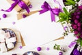 Mockup. Cards and flowers, box gift,violet ribbon and cloth lying on a white table. Royalty Free Stock Photo