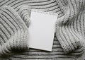 Mockup of cards at white textured watercolor paper background. Top view of spiral notebook Abstract knitting fabric