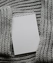 Mockup of cards at white textured watercolor paper background. Top view of spiral notebook Abstract knitting fabric