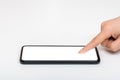 mockup cell phone lies on table and woman's hand tapping screen. hand with finger on blank touchscreen mobile phone. copy Royalty Free Stock Photo