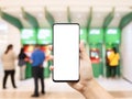 Mockup cellphone, hand using smart phone with empty blank screen with blurred image of people using ATM Automated Teller Machine