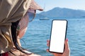 Mockup cellphone sea vacation. woman Hand Holding Cellphone With Blank Screen Against Sea Beach Outdoor. roaming on vacation Royalty Free Stock Photo