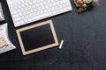 Mockup chalkboard with blank empty screen, new year gift box with Xmas christmas ornaments on black wood home office desk, top