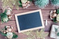 Mockup chalkboard with blank empty screen, new year gift box with Xmas pine tree model, christmas ornaments on wood background,