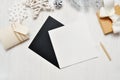 Mockup Christmas black greeting card letter in envelope and gift, flatlay on a white wooden background, with place for Royalty Free Stock Photo