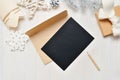 Mockup Christmas black greeting card letter in envelope and pencil, flatlay on a white wooden background, with place for Royalty Free Stock Photo