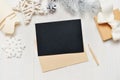 Mockup Christmas black greeting card letter in envelope with white tree, flatlay on a white wooden background, with Royalty Free Stock Photo