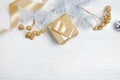 Mockup Christmas gift gold bow ribbon and tree cone, flatlay on a white wooden background, with place for your text Royalty Free Stock Photo