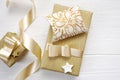 Mockup Christmas greeting card text Hohoho with gold gift ribbon, flatlay on a white wooden background