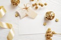 Mockup Christmas greeting card top view and gold ball, flatlay on a white wooden background with a ribbon, with place Royalty Free Stock Photo