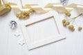 Mockup Christmas wood frame gold bow ribbon and tree cone, flatlay on a white wooden background, with place for your Royalty Free Stock Photo