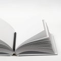 Mockup of closed blank square book and black pencil at white textured paper background Royalty Free Stock Photo