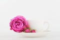 Mockup of coffee cup and rose flower on white desk with clean space for text and design your blogging.