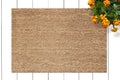 Mockup of Coir Doormat on wooden floor with flowers Royalty Free Stock Photo