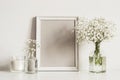 Mockup composition with photo frame, white flowers and candle. Copy space for artwork Royalty Free Stock Photo