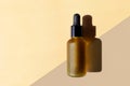 Mockup with copy space. Cosmetic oil bottle, beige diagonal background. Horizontal template of banner, poster. Dark brown frosted