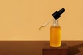 Mockup of cosmetic oil bottle with dropper removed on wooden stand. Horizontal monochrome brown banner, copy space. Natural lotion