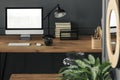 Mockup on desktop computer on wooden desk with lamp in grey work Royalty Free Stock Photo