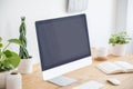 Mockup of desktop computer on wooden desk with plants in freelancer`s interior. Real photo Royalty Free Stock Photo