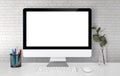 Mockup display screen blank computer on desk with white wall, office and workspace. Royalty Free Stock Photo