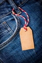 Mock up of empty brown paper price tag on blue jeans Royalty Free Stock Photo