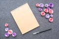 Mockup with empty sketchbook or notebook with brown kraft paper, black pen and paper pink and lilac roses on dark felt background Royalty Free Stock Photo