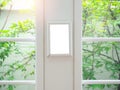 Mockup empty white vertical photo frame on vintage glass window with tree outside. Royalty Free Stock Photo