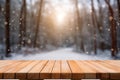 Mockup of empty wooden display product stand, table with blurred snow pine trees forest in morning sunlight, peaceful winter Royalty Free Stock Photo