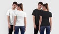 Mockup of a fashionable white, black T-shirt on a girl, back view, and a guy, front view, isolated on the background Royalty Free Stock Photo