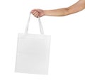 Mockup of female hand holding a blank Tote Canvas Bag isolated on white background
