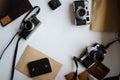 Mockup with film retro cameras on a white table. Leather notebooks