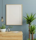 Mockup frame on cabinet in living room interior on empty dark blue wall background Royalty Free Stock Photo