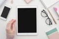 Mockup. Girl hand and digital tablet with blank screen, smartphone and notepad on table. Woman office workspace. Blog