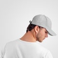 Mockup gray baseball cap heather on the head of a man, sports panama with a visor, isolated on background, back view, side Royalty Free Stock Photo