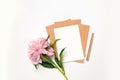 Mockup of horizontal business craft envelope with a sheet of white paper with bouquet of beautiful peonies on a gray background Royalty Free Stock Photo