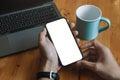 Mockup image blank white screen cell phone.men hand holding texting using mobile relax on sofa at home. background empty Royalty Free Stock Photo