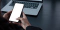 Mockup image blank white screen cell phone.women hand holding texting using mobile on desk at home office Royalty Free Stock Photo