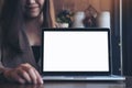 Mockup image of a business woman presenting and showing laptop with blank white screen on wooden table Royalty Free Stock Photo