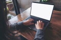 Mockup image of business woman using and typing on laptop with blank white screen and coffee cup on glass table Royalty Free Stock Photo