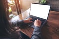 Mockup image of business woman using and typing on laptop with blank white screen and coffee cup on glass table Royalty Free Stock Photo