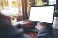 Mockup image of business woman using and typing on laptop with blank white screen and coffee cup on glass table Royalty Free Stock Photo