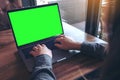 Mockup image of business woman using and typing on laptop with blank white screen and coffee cup on table Royalty Free Stock Photo