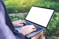 Mockup image of business woman using and typing on laptop with blank white screen and coffee cup on wooden table Royalty Free Stock Photo