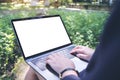 Mockup image of business woman using and typing on laptop with blank white screen , sitting at outdoor Royalty Free Stock Photo