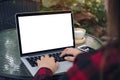 Mockup image of business woman using and typing on laptop with blank white screen , smart phone and coffee cups on glass table Royalty Free Stock Photo