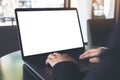 Mockup image of business woman using and typing on laptop with blank white screen on table Royalty Free Stock Photo