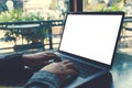 Business woman using and typing on laptop with blank white screen on table in modern cafe Royalty Free Stock Photo