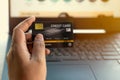 Mockup image of a hand holding credit card while using and typing on laptop.online shopping, online payment Royalty Free Stock Photo